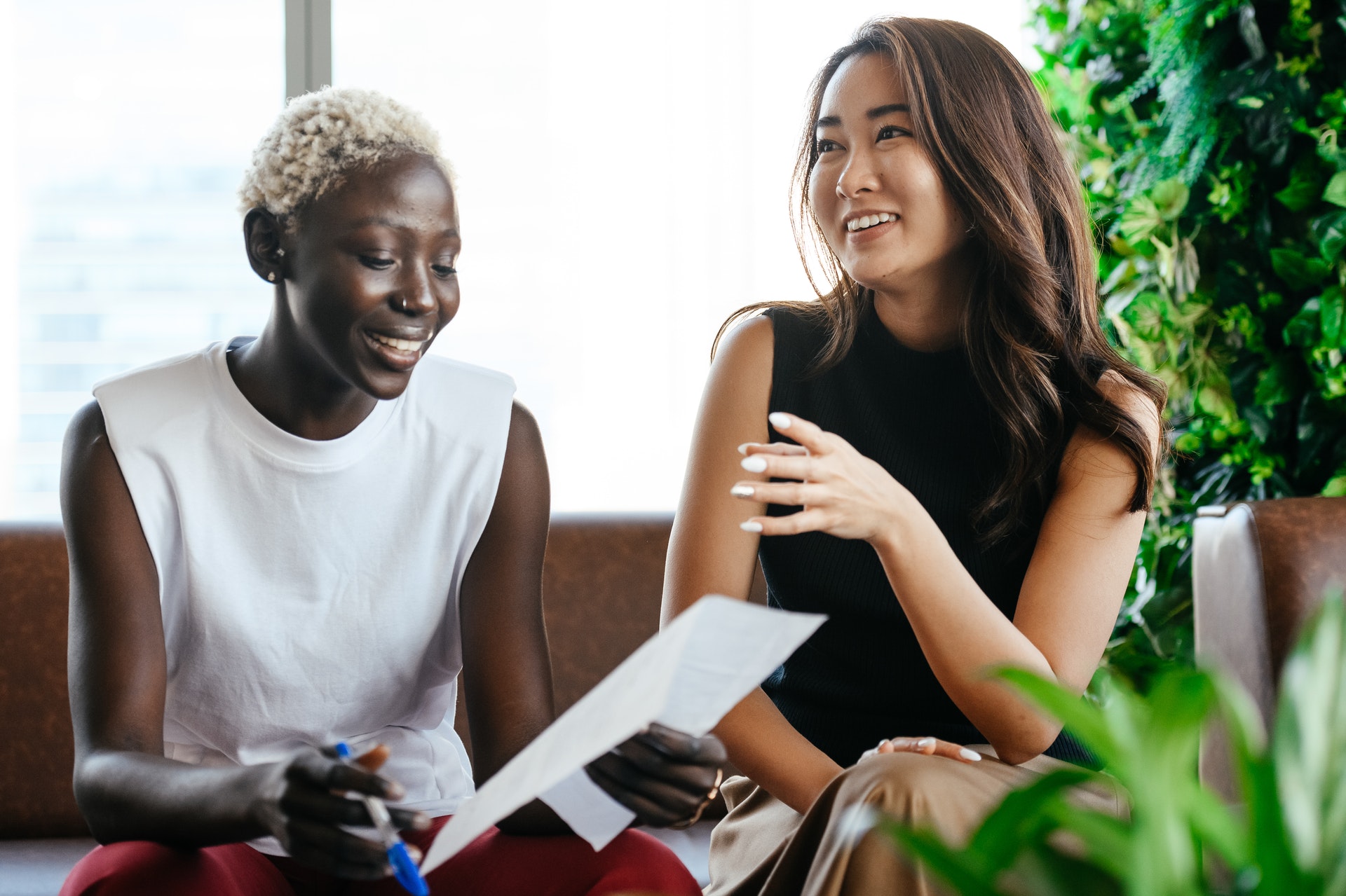 two-women-smiling-together Employee and manager reviewing employee evaluation