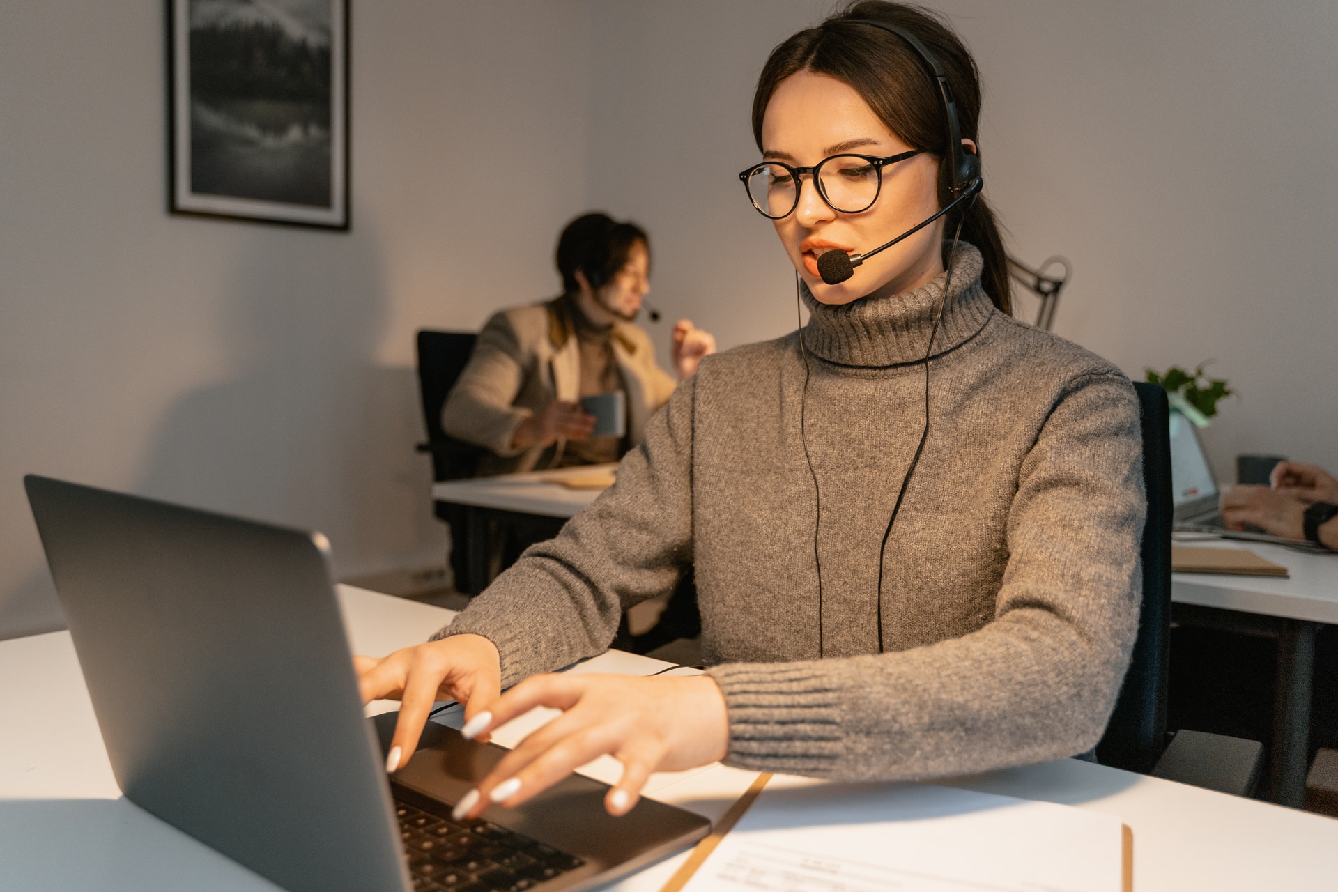 Woman using laptop wearing headset discussing employee engagement ideas