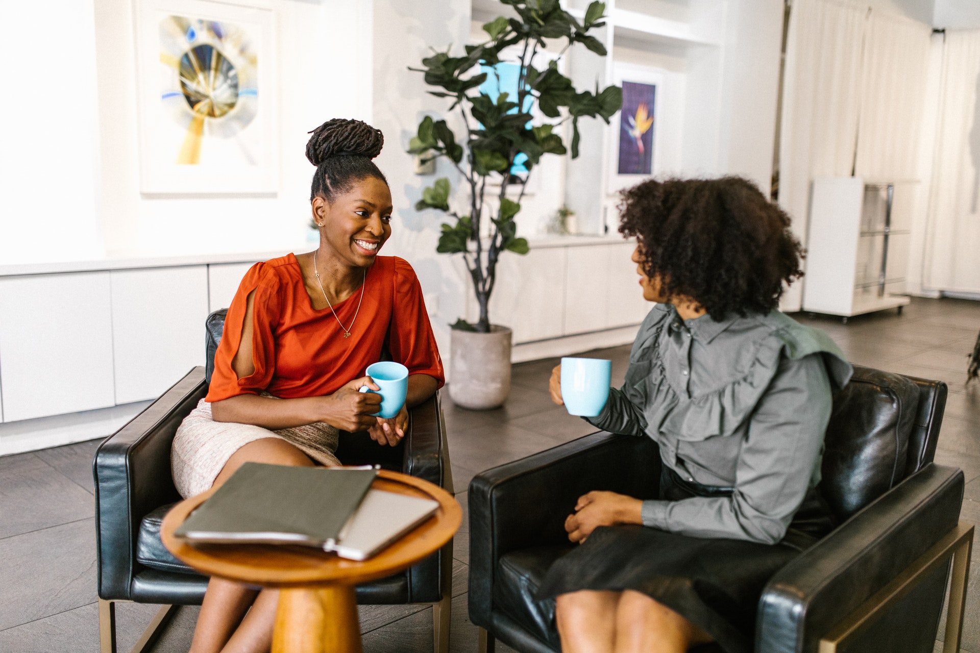 two-professional-black-women-interacting Two corporate Black women discussing performance review questions