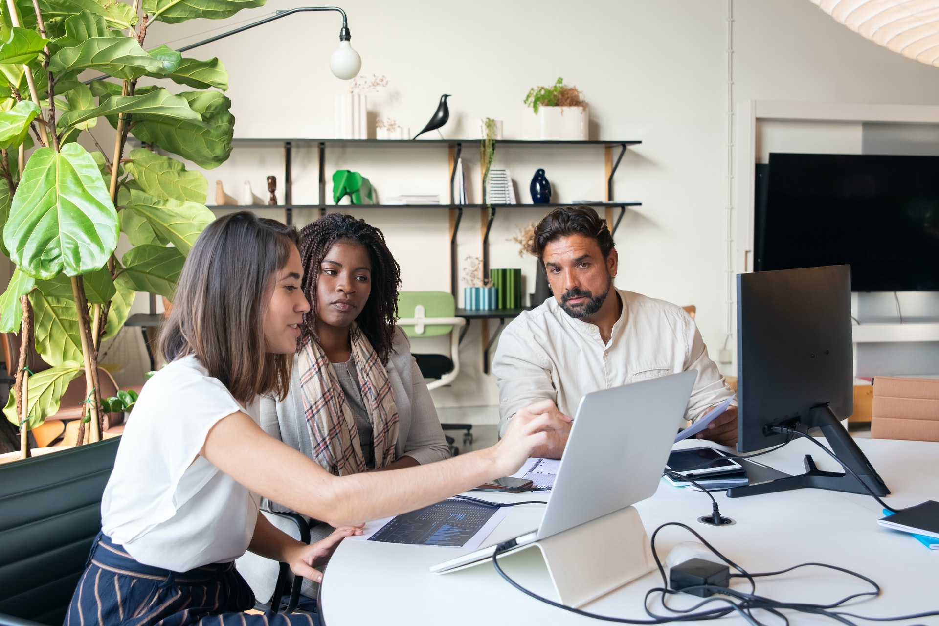 Three colleagues sitting discussing HR tech on laptop
