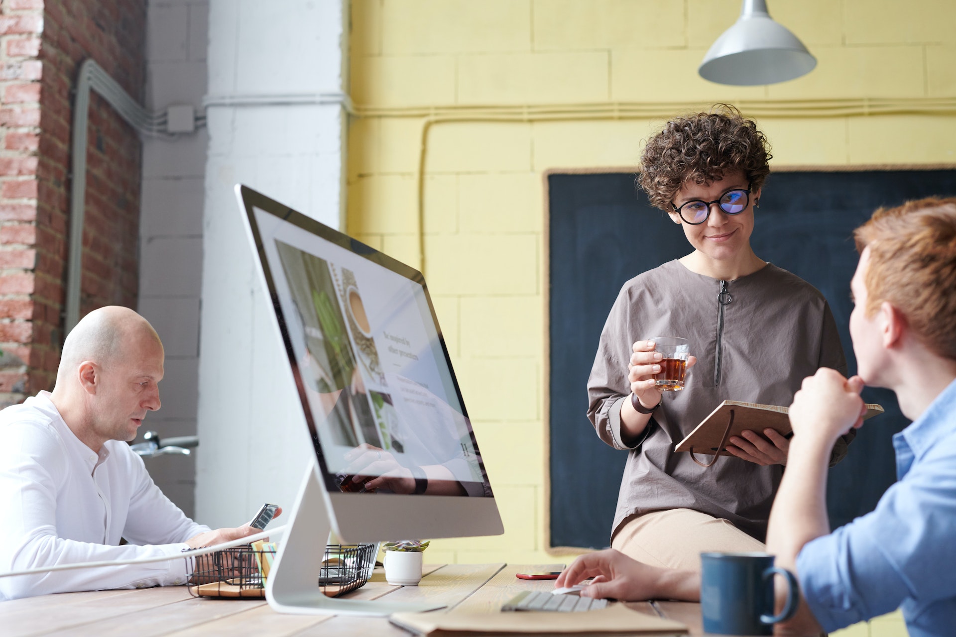 Standing woman discussing benefits packages with colleague