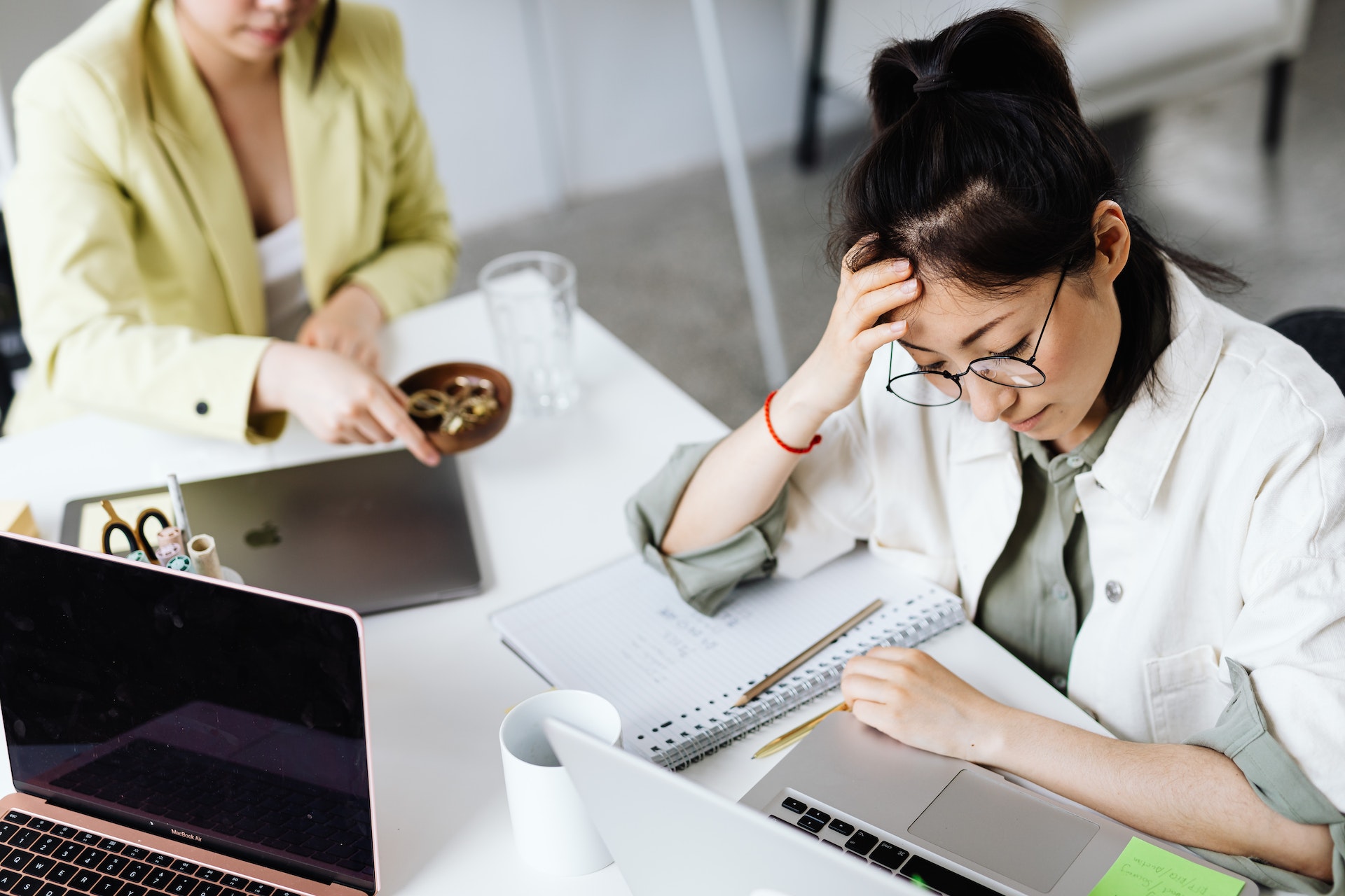 women-desk-laptops Overworked employees at desk with laptops