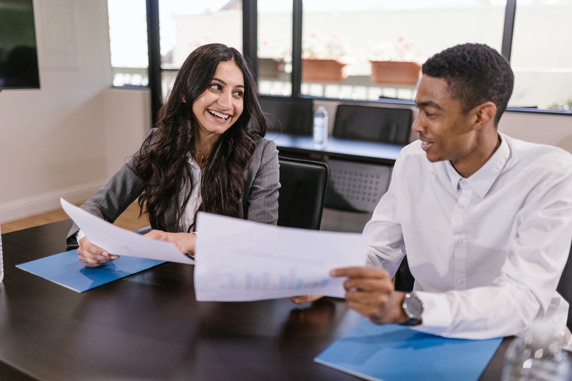 Woman of colour and Blak man giving each other workplace feedback